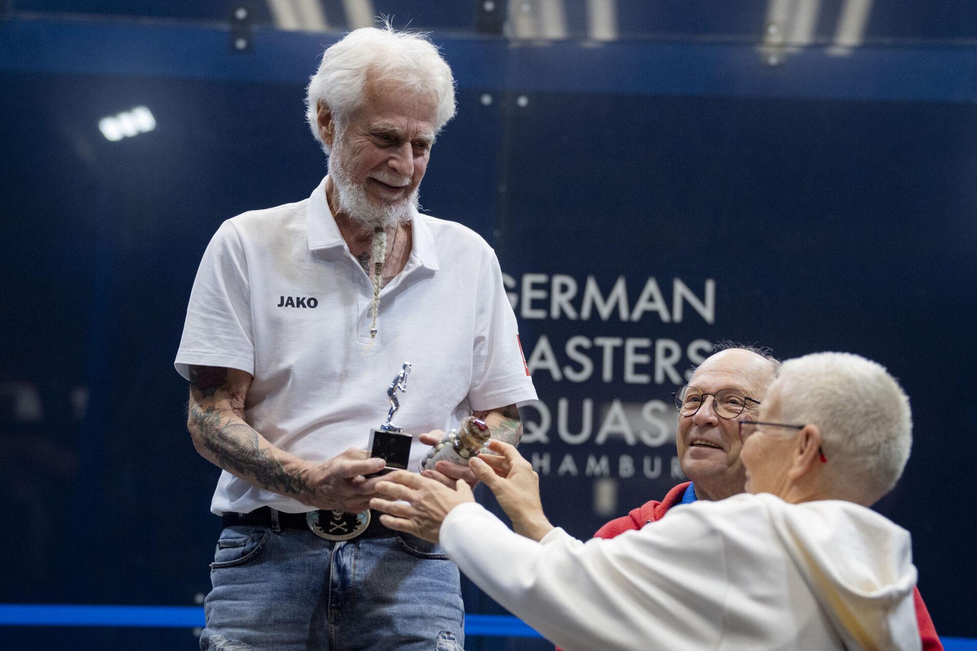 Bernd G&ouml;tsch bekommt den Pokal f&uuml;r seinen Platz eins in der M75+ von DSQV-Vizepr&auml;sidentin Masters St&ouml;rte Becker &uuml;berreicht - Bild: Henning Angerer