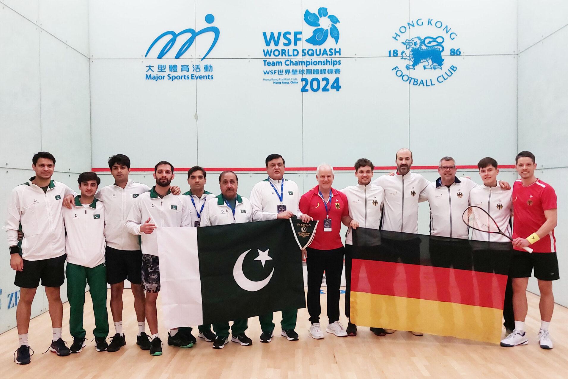 Team Pakistan (li) und Team Deutschland (re, 1.v.l. an der deutschen Fahne: Physiotherapeut Ralph Michna, rechts daneben v.l.n.r.: Valentin Rapp, Simon Rösner, Chef-Bundestrainer Oliver Pettke, Yannik Omlor und Raphael Kandra) - Bild: DSQV