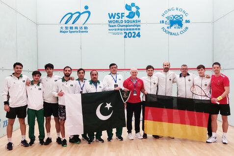 Team Pakistan (li) und Team Deutschland (re, 1.v.l. an der deutschen Fahne: Physiotherapeut Ralph Michna, rechts daneben v.l.n.r.: Valentin Rapp, Simon R&ouml;sner, Chef-Bundestrainer Oliver Pettke, Yannik Omlor und Raphael Kandra) - Bild: DSQV