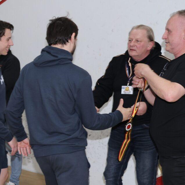 Peter Schmidl (1.v.r.) und Johannes Wessela (2.v.r.) begl&uuml;ckw&uuml;nschen die Spieler von Sportwerk Hamburg zum Gewinn der Deutschen Mannschaftsmeisterschaft 2026 - Bild: Christian Lortat