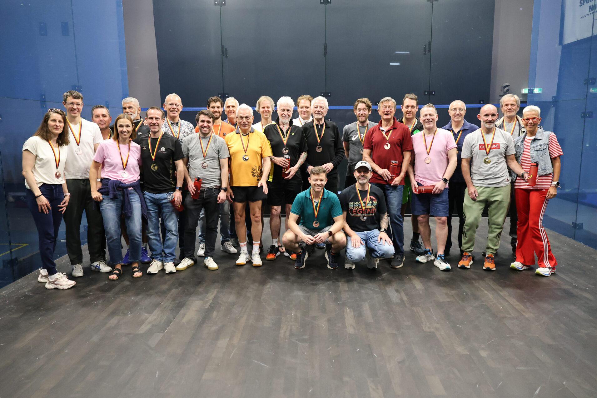 Gruppenbild vieler Podestplatzierter bei den DSEM 2026 zusammen mit DSQV-Vizepräsidentin Masters Störte Becker (re) - Bild: DSQV - Lennard Jessen