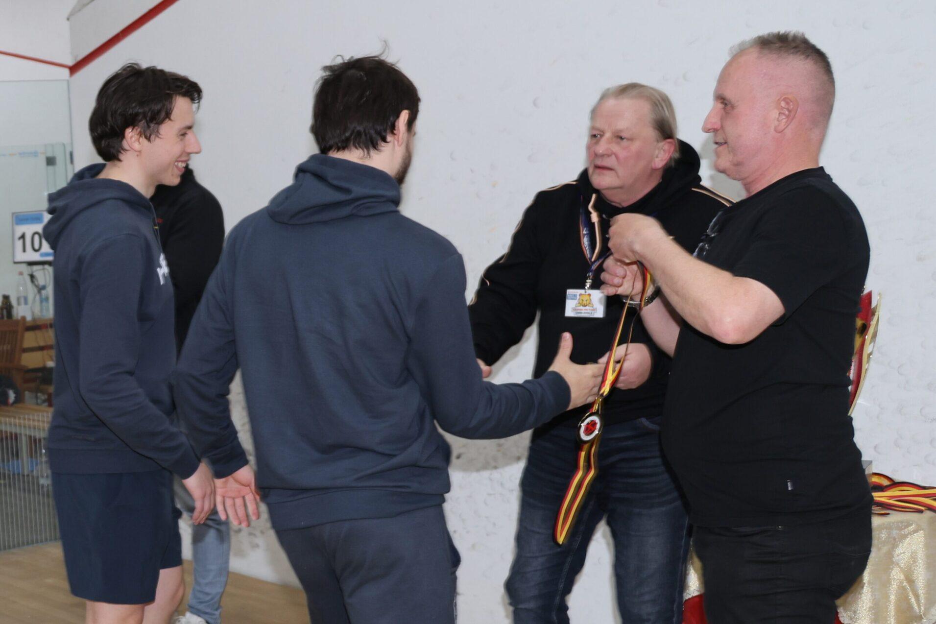 Peter Schmidl (1.v.r.) und Johannes Wessela (2.v.r.) begl&uuml;ckw&uuml;nschen die Spieler von Sportwerk Hamburg zum Gewinn der Deutschen Mannschaftsmeisterschaft 2026 - Bild: Christian Lortat